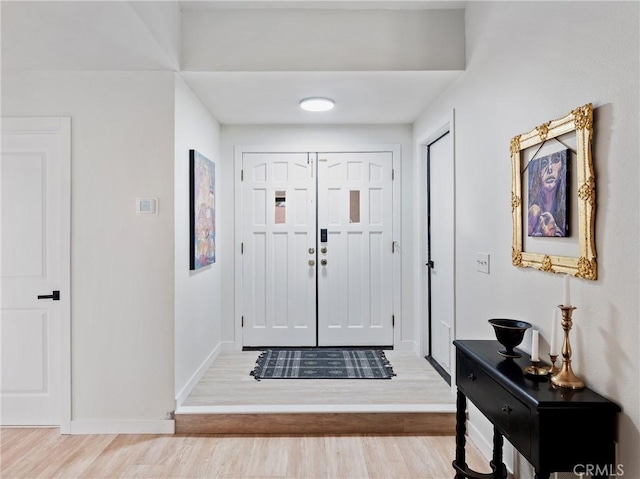 entrance foyer with baseboards and wood finished floors