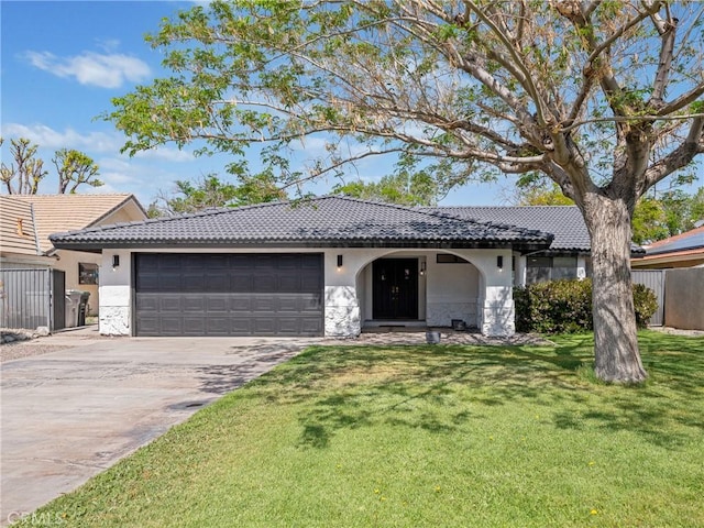 view of front facade featuring a tile roof, a garage, stucco siding, a front yard, and concrete driveway