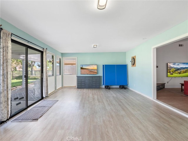 unfurnished living room with baseboards, wood finished floors, and visible vents