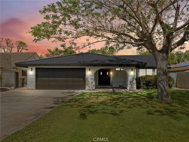 view of front of home featuring concrete driveway, an attached garage, a tile roof, and stucco siding