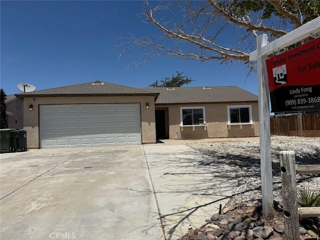 10434 Peach Ct, Adelanto, CA 92301 - view of front of home with stucco siding, a garage, and concrete driveway