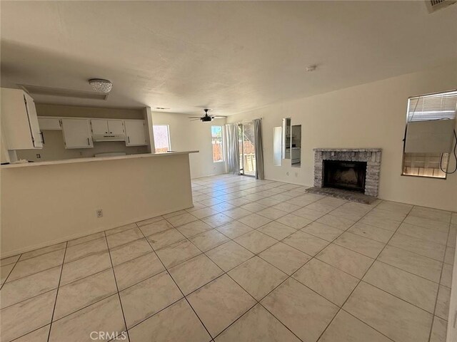 10434 Peach Ct, Adelanto, CA 92301 - unfurnished living room featuring light tile patterned floors, a fireplace with raised hearth, and a ceiling fan