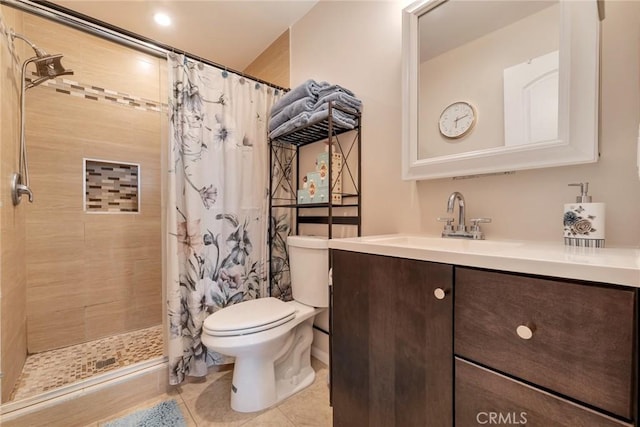full bathroom featuring vanity, tile patterned flooring, toilet, and tiled shower
