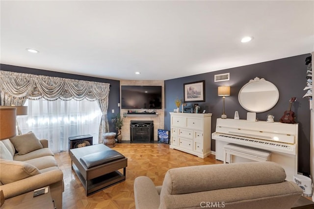 living area featuring baseboards, a fireplace, recessed lighting, and visible vents