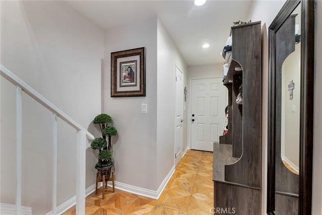 hallway featuring baseboards, recessed lighting, and stairs