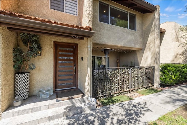 entrance to property featuring stucco siding