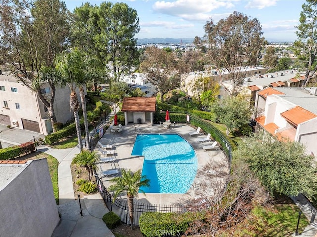 pool with fence, a patio area, and a residential view
