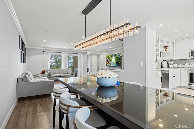 dining space featuring crown molding, baseboards, light wood-style floors, and recessed lighting