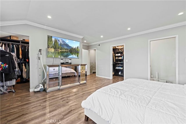 bedroom featuring visible vents, wood finished floors, baseboards, recessed lighting, and a spacious closet