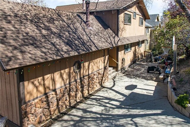 1411 Sequoia Dr, Lake Arrowhead, CA 92352 - view of home's exterior with a patio, roof with shingles, fence, and stone siding