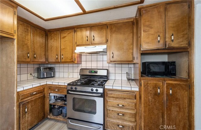 1411 Sequoia Dr, Lake Arrowhead, CA 92352 - kitchen featuring gas stove, tile counters, backsplash, and under cabinet range hood