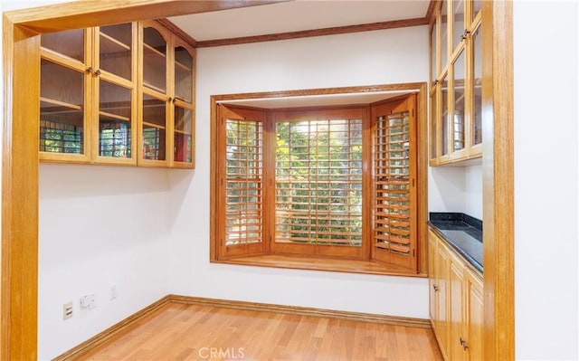 unfurnished dining area featuring baseboards and wood finished floors