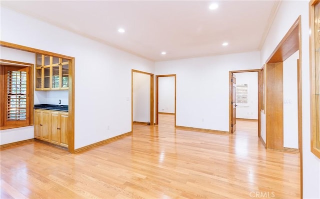 interior space with crown molding, recessed lighting, baseboards, and light wood-style floors