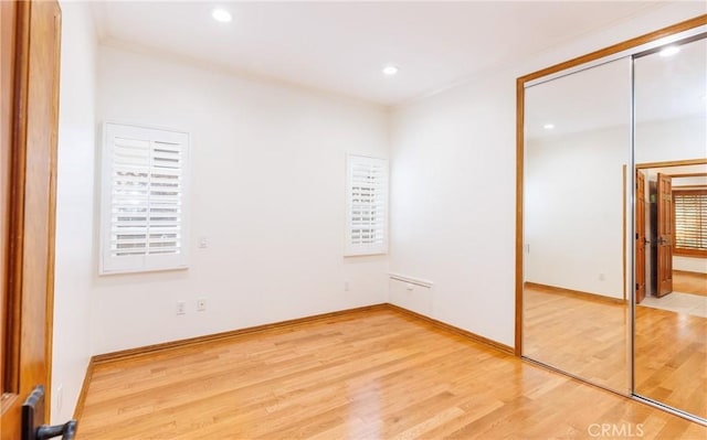 unfurnished bedroom featuring light wood-style floors, baseboards, a closet, and recessed lighting