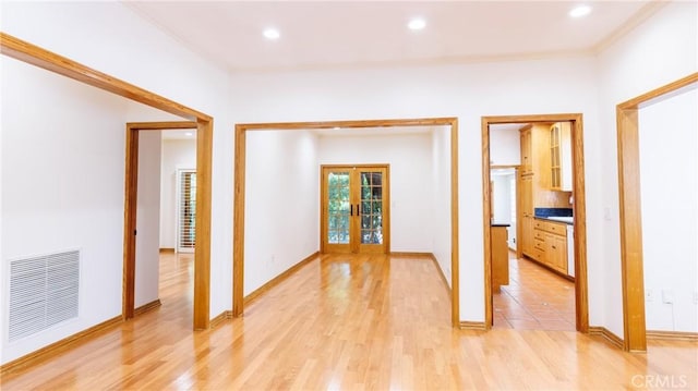 hallway featuring french doors, light wood-style flooring, recessed lighting, visible vents, and ornamental molding