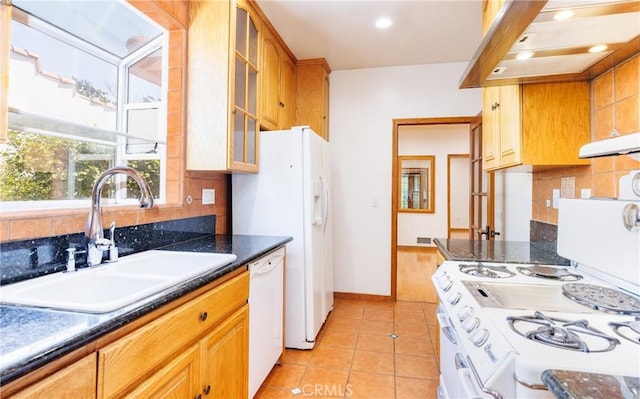 kitchen featuring decorative backsplash, a sink, light tile patterned floors, glass insert cabinets, and white appliances