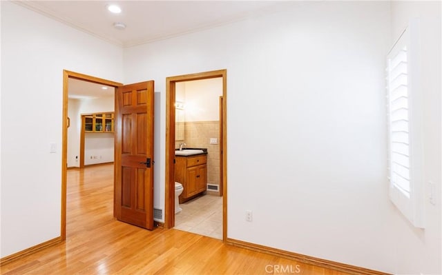interior space with a sink, light wood-style floors, recessed lighting, visible vents, and ornamental molding