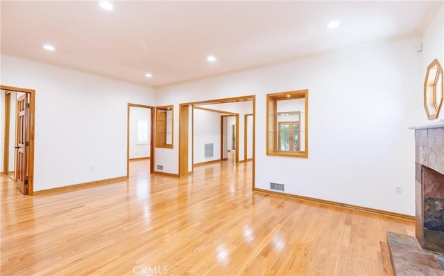 unfurnished living room featuring visible vents, light wood-type flooring, recessed lighting, and a tile fireplace
