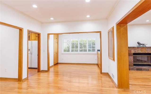 hall with visible vents, crown molding, light wood-type flooring, baseboards, and recessed lighting