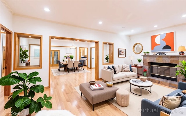 living area featuring crown molding, recessed lighting, wood finished floors, and a premium fireplace
