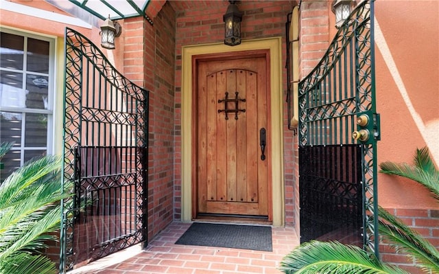 property entrance with brick siding and a gate