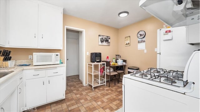 kitchen featuring white appliances, white cabinetry, ventilation hood, and light countertops