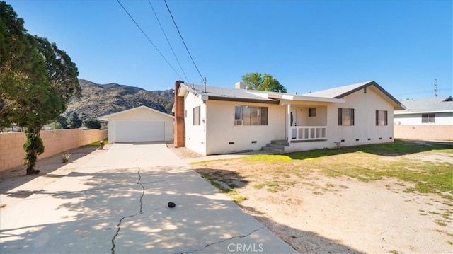 view of front of property with fence, a garage, crawl space, a mountain view, and an outdoor structure