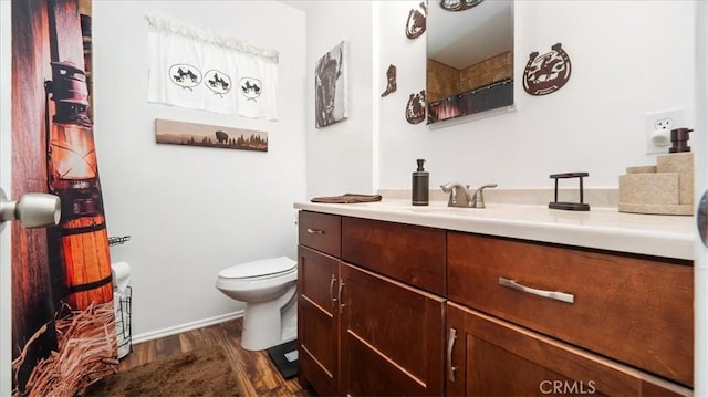 full bath featuring vanity, wood finished floors, and toilet