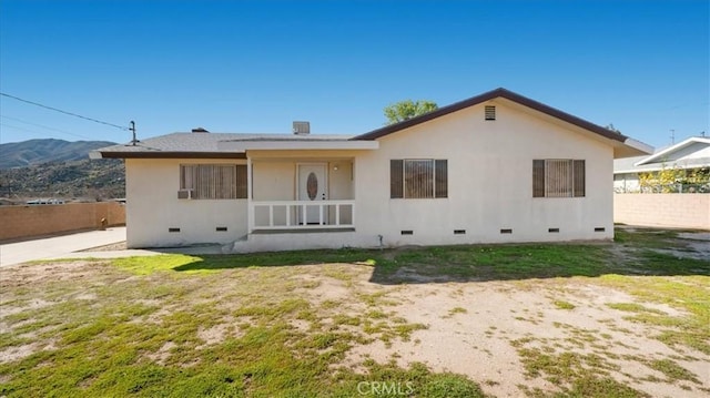 rear view of property featuring crawl space, fence, and a mountain view