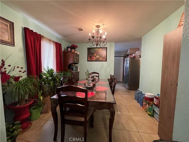 dining area featuring visible vents, light tile patterned flooring, and a chandelier