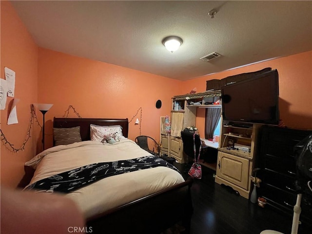 bedroom with visible vents and wood finished floors