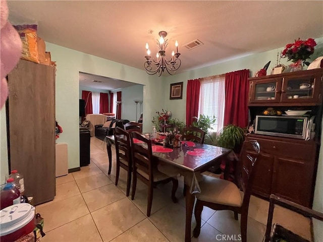 dining space featuring visible vents, light tile patterned flooring, and an inviting chandelier