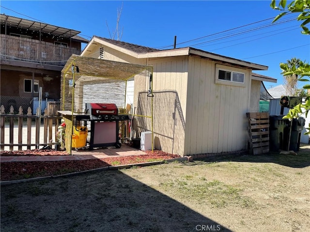 view of side of home featuring fence and a balcony