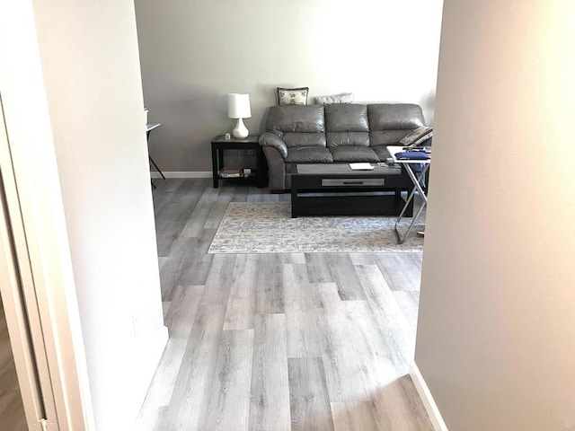 living area with baseboards and wood finished floors