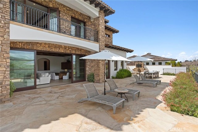 view of patio / terrace with fence and a balcony