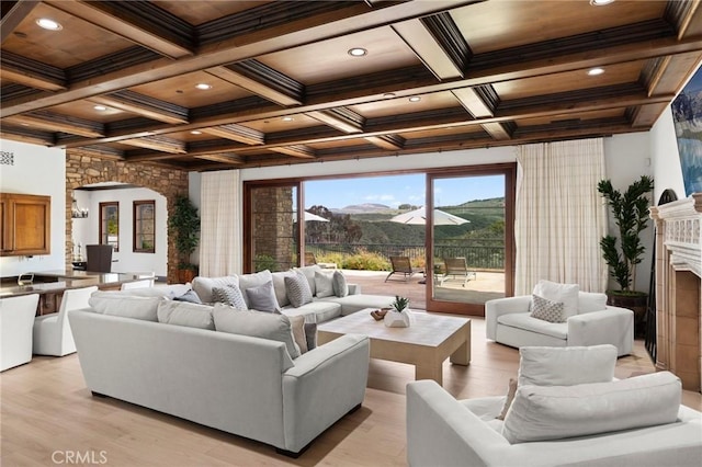living area featuring beam ceiling, a fireplace, arched walkways, recessed lighting, and coffered ceiling