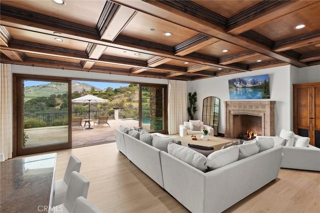 living area featuring a wealth of natural light, a premium fireplace, and beamed ceiling