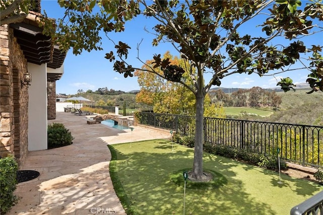 view of yard with a fenced in pool, a mountain view, a fenced backyard, and a patio area