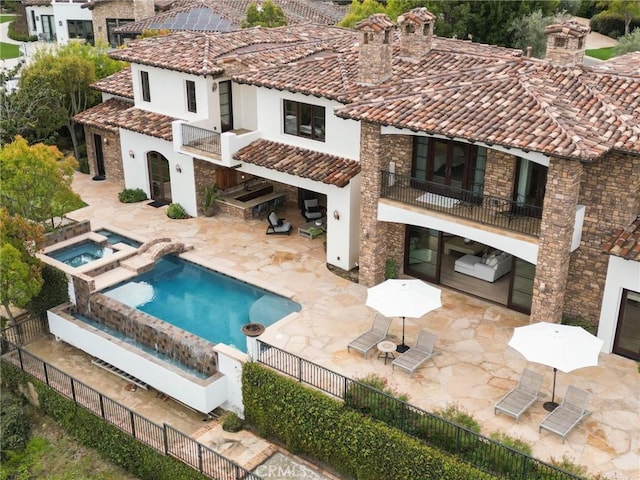 back of house with a patio, a fenced backyard, a balcony, and a tiled roof