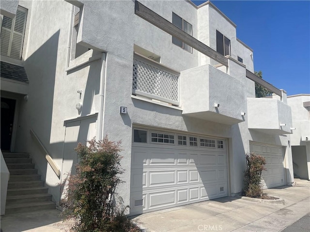 5727 E Stillwater Ave Unit 5, Orange, CA 92869 - view of side of home with an attached garage, a balcony, and stucco siding