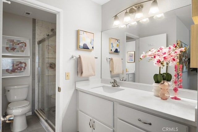bathroom featuring toilet, a shower stall, tile patterned flooring, and vanity