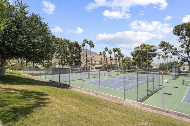 view of sport court featuring a yard and fence