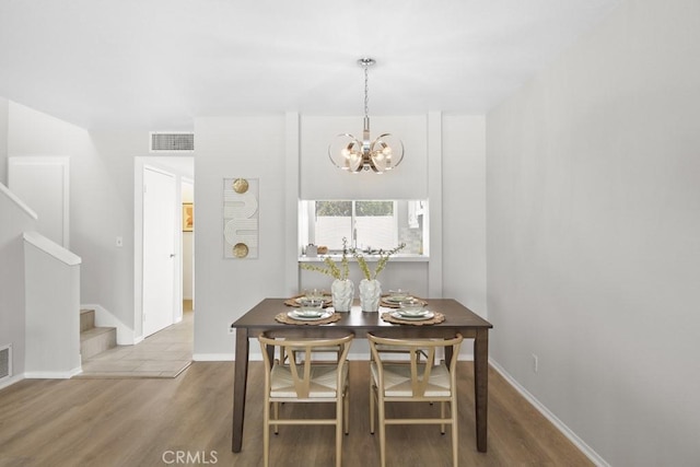48668 Desert Flower Dr, Palm Desert, CA 92260 - dining area with wood finished floors, a chandelier, stairs, and baseboards