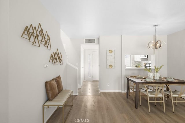 48668 Desert Flower Dr, Palm Desert, CA 92260 - dining area with wood finished floors, a chandelier, and baseboards