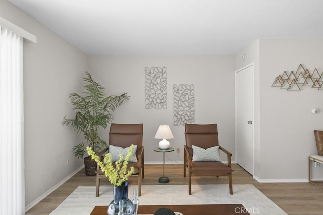 living area featuring baseboards and wood finished floors