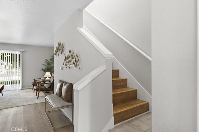 staircase with baseboards and wood finished floors