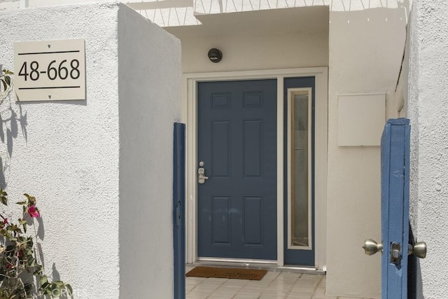 doorway to property featuring stucco siding