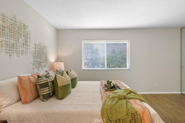bedroom featuring baseboards and wood finished floors