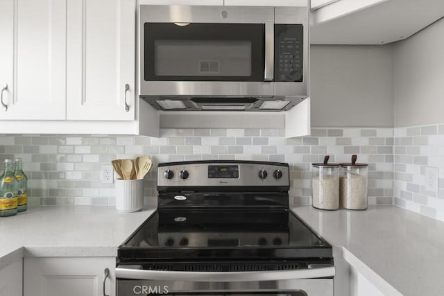kitchen featuring appliances with stainless steel finishes, backsplash, and white cabinetry