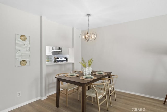 48668 Desert Flower Dr, Palm Desert, CA 92260 - dining area featuring wood finished floors, baseboards, and a chandelier
